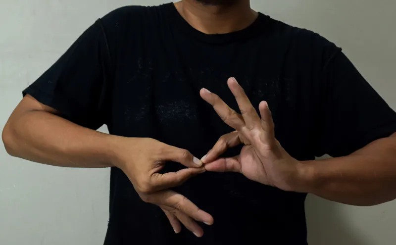 Pessoa sinalizando em Libras com as duas mãos